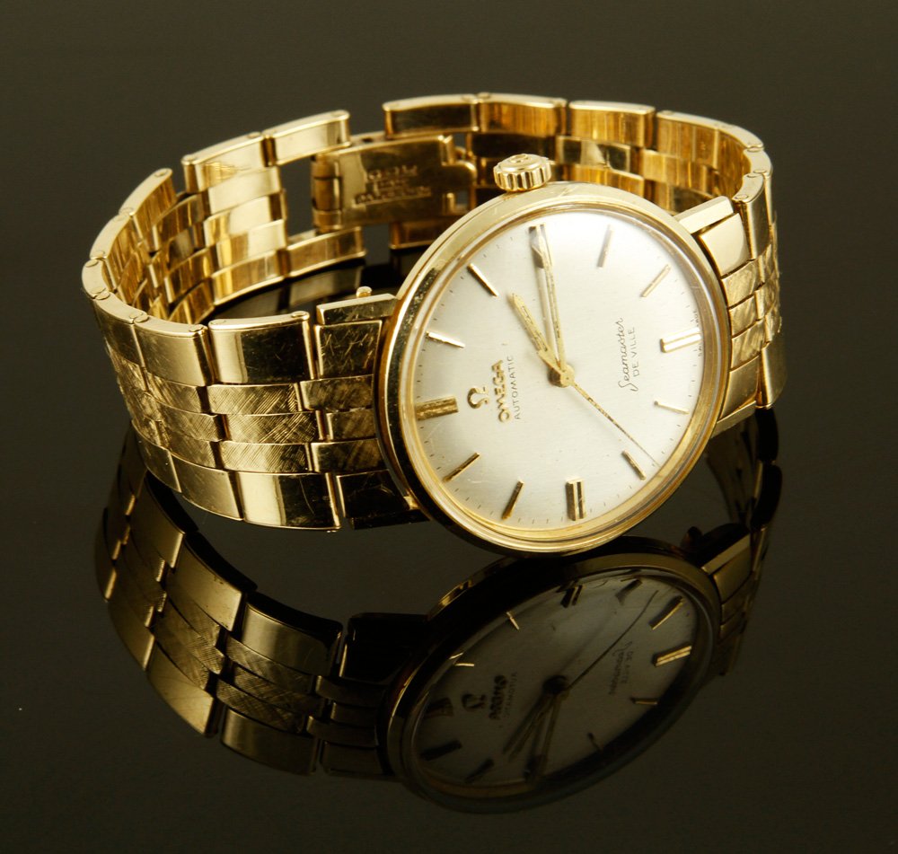 14K Omega Watch: 14k Omega automatic Seamaster Deville watch, marked 14k gold on band and case, case is 1 5/16"dia, band is 7 1/4"l, approximately 65 g. TW, including movement. Provenance: From a Massachusetts collect