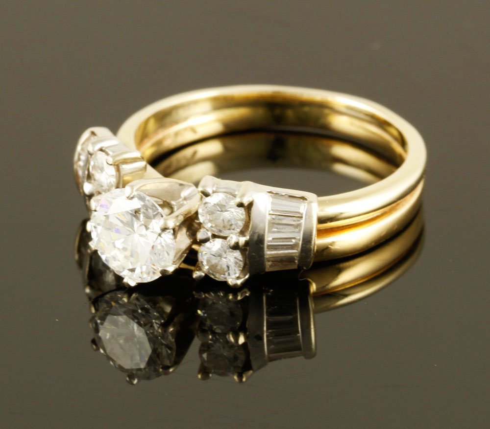 14K Gold and Diamond Ring: 14K yellow gold and diamond ring with white gold settings, center round brilliant cut diamond approximately 0.75 ct. with four smaller round brilliants and eight baguettes, approximately 6 g. TW, size