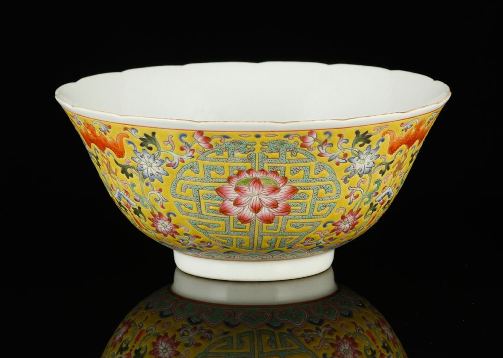 Chinese Famille Rose Porcelain Bowl: Famille rose porcelain bowl, China, round shape, gilt on petal-shaped rim, decorated with red bats and lotus flowers surrounded by green Shou and Wan characters on yellow ground, with continuous Ruyi 