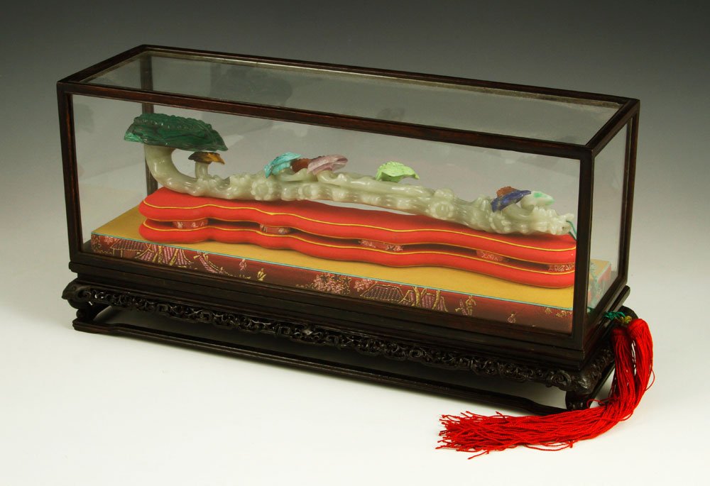 Chinese Jade Ruyi Scepter: Jade ruyi scepter, China, 19th century, carved in naturalistic form with multicolored mushroom heads throughout, the large face dark green, with red double tassel at end, on silk rest in shape of scep