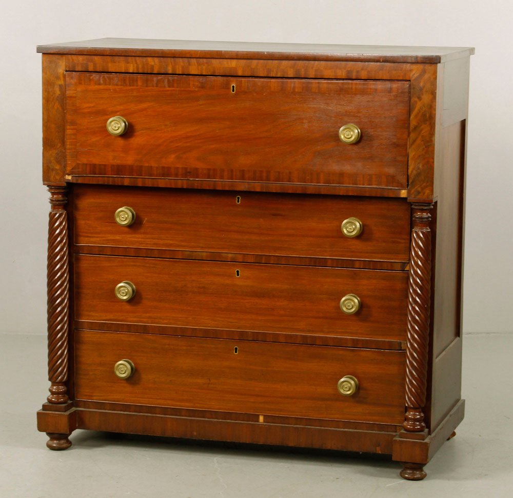 Empire Style Mahogany Butler's Chest: Empire style butler's chest, mahogany, having fall front desk with fitted interior over three drawers, drawers flanked by turned columns, with brass pulls, raised on bun feet, 44" h x 43" w x 22" d. P