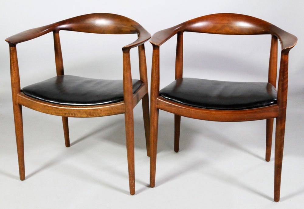Pr. Hans Wegner Armchairs: Pair of Hans Wegner armchairs, "the chair," or "the round chair," c. 1950s, light brown finish with black leahter seats, likely early contract furniture, unmarked save a 1950s era Upholster's Internat