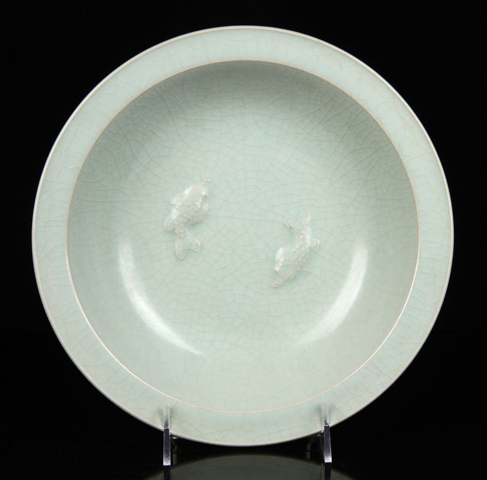 Celadon Green Glazed Pottery Plate: Celadon green glazed pottery plate, Ming Dynasty style, decorated with carved double fish in center, 9 3/4" d.