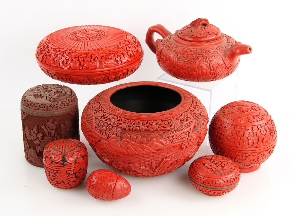Lot of 8 Chinese Red Lacquer Items: Lot of eight Chinese red lacquer items, to include: one Yixing clay teapot, 4" h x 8" w x 6" dia; one lacquer over carved wood bowl, 4 1/2" h x 8" dia; one circular box, 3" h x 7" dia; one spherical b