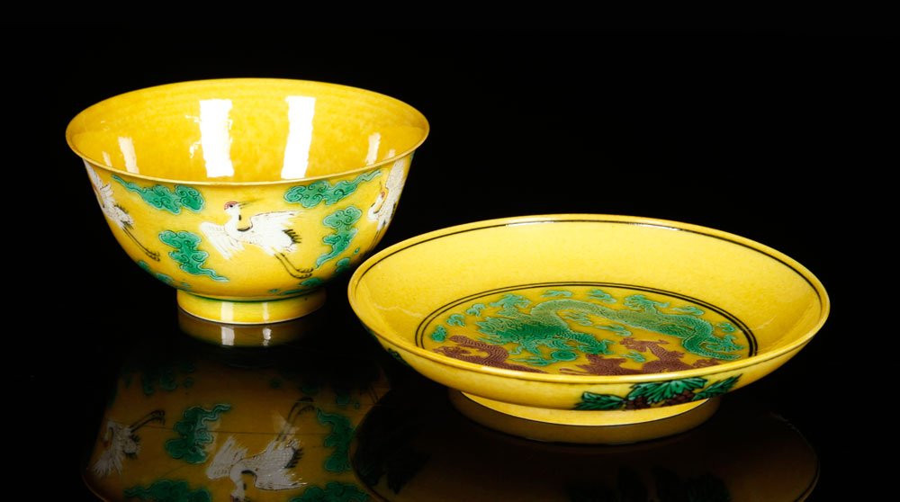 Chinese Yellow Glazed Bowl and Plate, Porcelain: Chinese yellow glazed bowl and plate, porcelain, cup decorated with storks among clouds, plate decorated with two dragons and grape clusters, 6" dia.