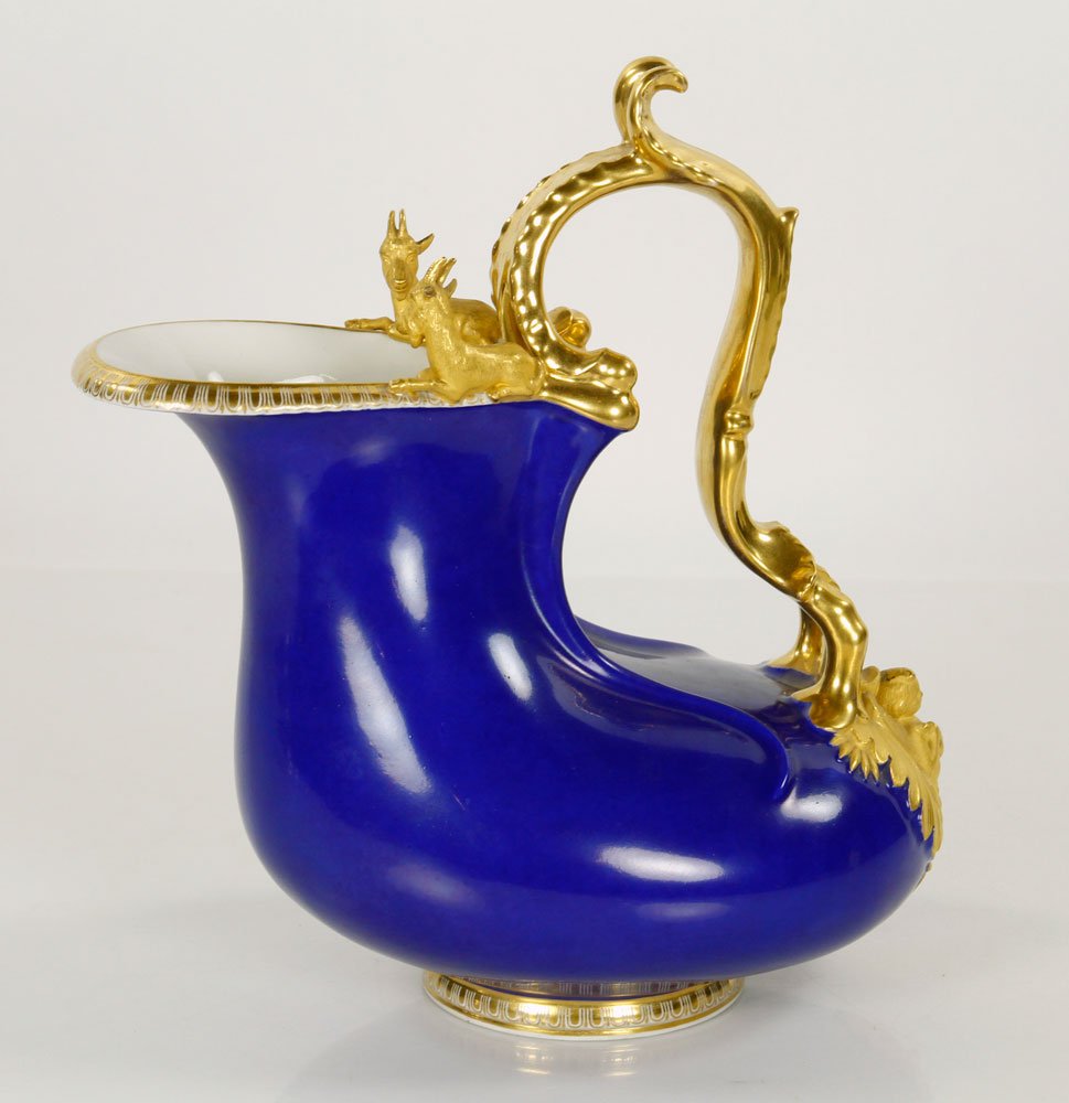 KPM Ewer: KPM cobalt blue ewer, porcelain with gilt decoration, with two goats at top, marked on base, 9" h x 8" w. Provenance: From a New York collection.