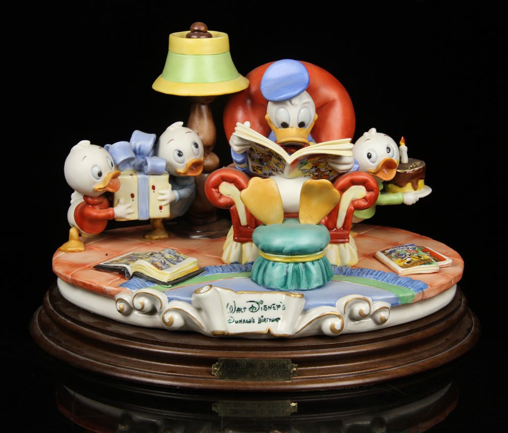 Capodimonte "Walt Disney's Donald's Birthday" Figural: Capodimonte "Walt Disney's Donald's Birthday" figural group, porcelain, editioned of 2500, 8 1/4" h x 13" w x 9 1/4" d. Provenance: From a New Hampshire estate.