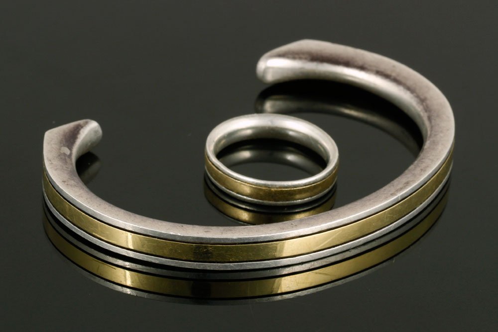 Cartier 18K Gold and Sterling Bracelet with Matching: Cartier bracelet and matching ring, 18k yellow gold and sterling silver, 34 g total weight, 2 1/8" w wrist opening, ring size 6. Provenance: From a Massachusetts estate.