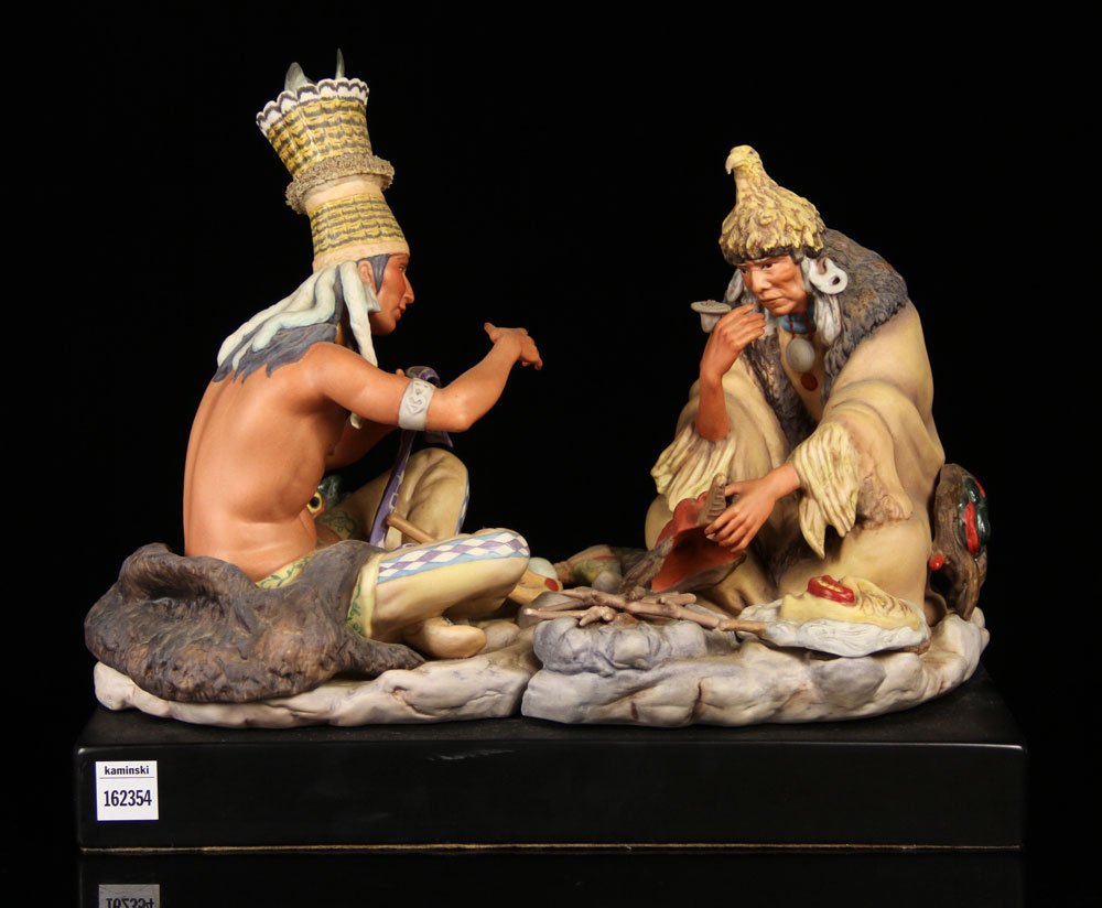 Cybis Figural Group, Porcelain: Cybis figural group, porcelain, depicting two Native American men with masks, on base, 14" h x 16" w x 9 1/2" d (including base). Provenance: From a New Hampshire estate.