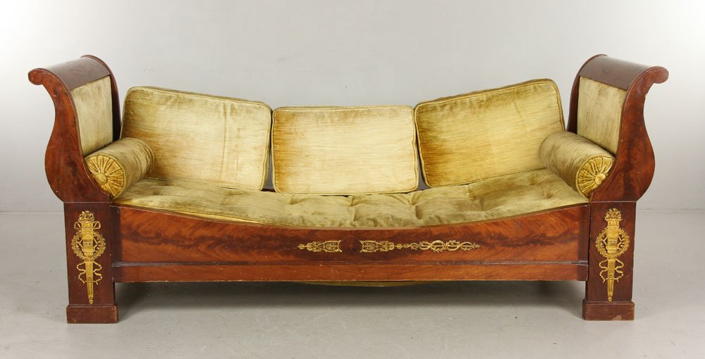 French Empire Canape: Circa 1810, French Empire Mahogany and ormolu canap, flanked by fielded ogee form sides down curving to the shaped rails, the ormolu (gilded bronze mounts) including flaming torchieres, bow tied ribba