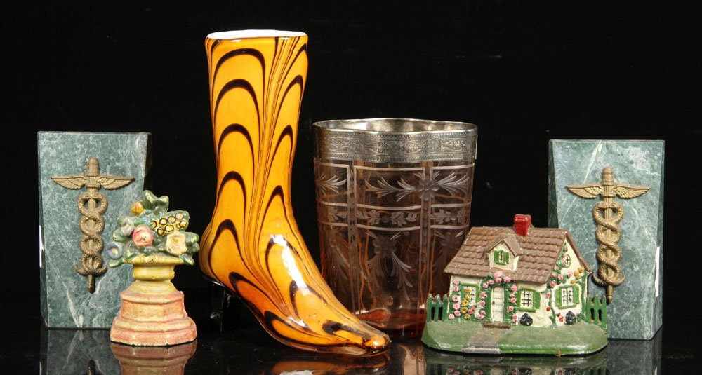 Lot of Decorative Items: Lot of decorative items, to include: two book ends, polychromed, one shaped like house, one like bouquet of flowers; two door stops, green stone with Caduceus; two-toned brown glass boot; and pink-ton