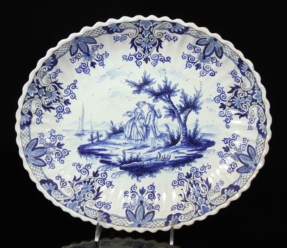 Delft Platter, Blue and White: Delft platter, blue and white, decorated with figures looking out to sea with boat, base marked "497 Delft," 12 3/4" l x 11" w. Provenance: Unreserved estate collection from a North Shore home.