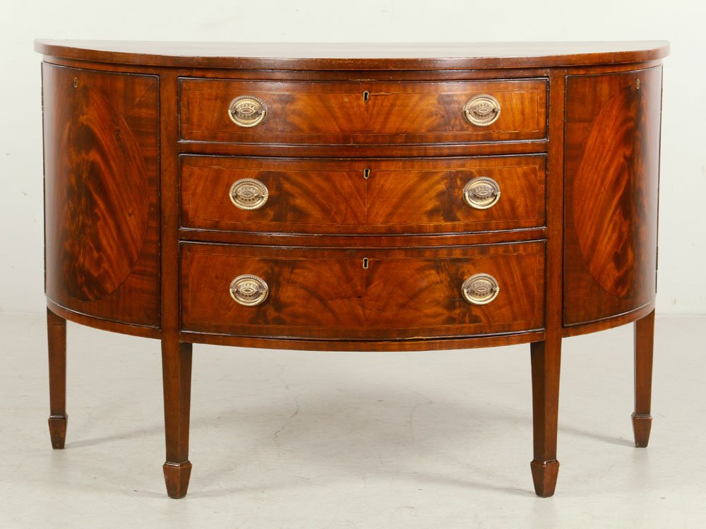 Hepplewhite Demilune Cabinet: 1940's Hepplewhite style demilune cabinet, mahogany and string inlay, having three drawers and two doors, 34" h x 52 1/2" w x 24" d. Provenance: from a New York estate.