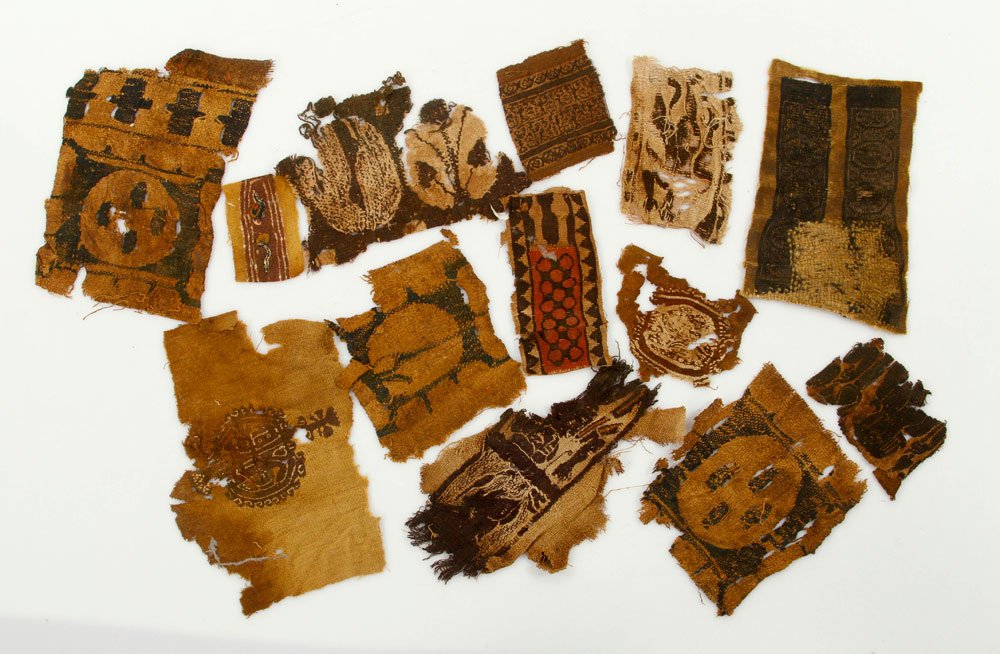 Lot of 4th to 5th C. Coptic Textile Fragments: Lot of thirteen Coptic textile fragments, 4th to 5th century, largest 8" h x 5" w; Coptic cloth is a fine, dense fabric produced in the 2nd - 8th centuries AD, by the Copts, Christian descendants of t