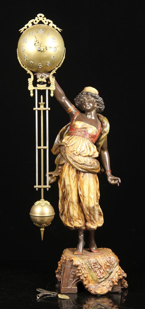 Victorian Figural Mystery Ball Swing Clock: Victorian figural mystery ball swing clock, cast metal with original polychrome paint, depicting a black Moor maiden standing on a carpet, 27" h. Provenance: From a California estate.