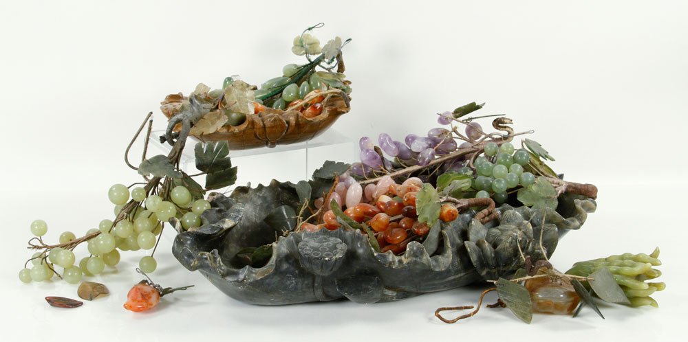2 Soapstone Bowls with Carved Stone Fruit: Two carved soapstone bowls, filled with carved grapes, pears and other fruit made of semi-precious stones, including amethyst, rose quartz and more; largest bowl measuring 22" l. Provenance: From a Ma
