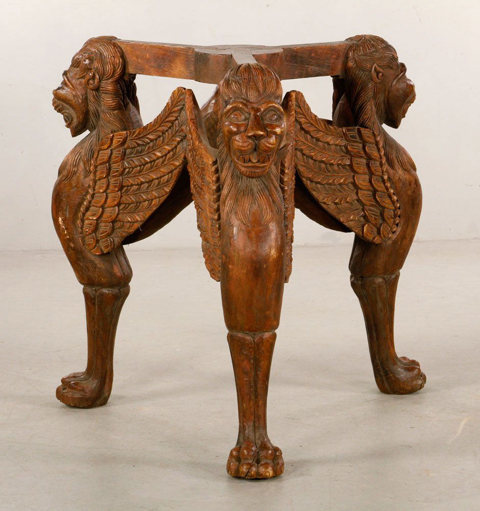 Lion Table Base: Carved wood table base, with winged lion motif, 30 1/4" h x 30" dia. Provenance: From the estate of interior designer Thomas Britt.
