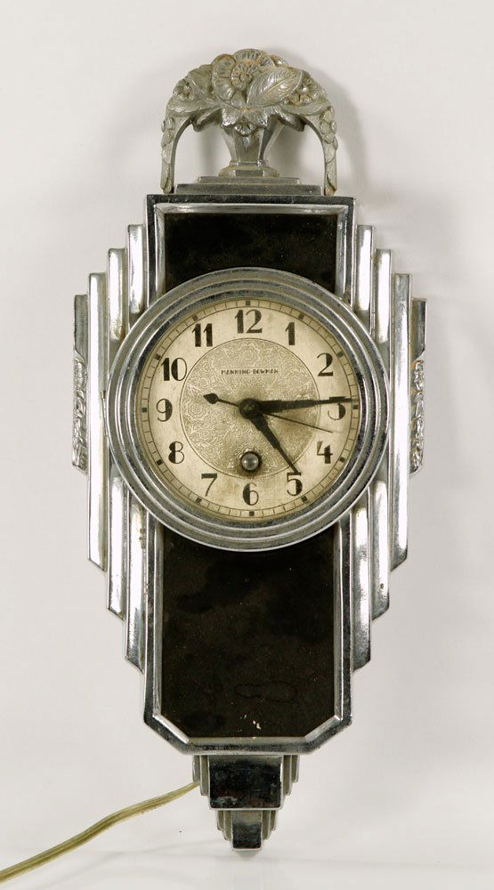 Manning Bowman and Co. Art Deco Clock: 1914 Manning Bowman and Co. Art Deco wall clock, chrome, having a bouquet-in-urn finial at top, electrified, patent no. 1719805. Provenance: from a Massachusetts private collector.