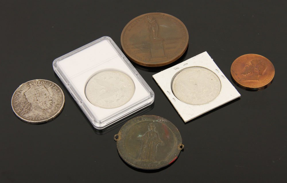Collection of Six Coins: Small collection of six coins, to include: two American silver dollars, dated 1898 and 1886; two British colonial coins; two bronze medallions. Provenance: from the lifelong collection of a Kansas Cit