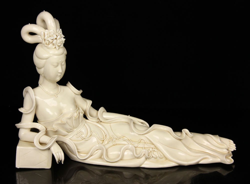 Dehua Blanc de Chine Reclining Figure: 19th-20th century reclining figure, Dehua blanc de chine porcelain, having a flowing gown and three symmetrical tall buns indicative of the Tang Dynasty, with fisherman mark, 10 3/4" h x 16" l. Proven