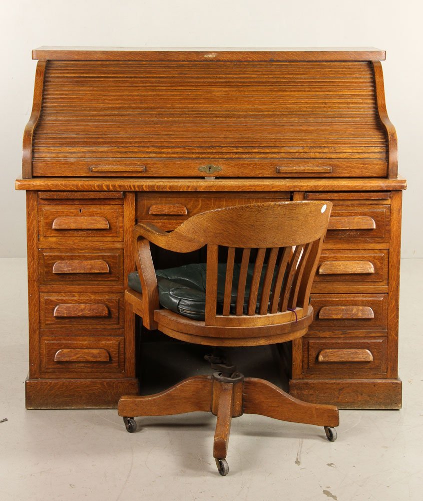 Antique Golden Oak Office Desk and Chair: Antique golden oak roll top office desk with swivel chair, with Bradford label and original keys, 46" h x 50" w x 34" d (view), 32" h x 23" w x 26" d (frame). Provenance: From the personal lifetime co