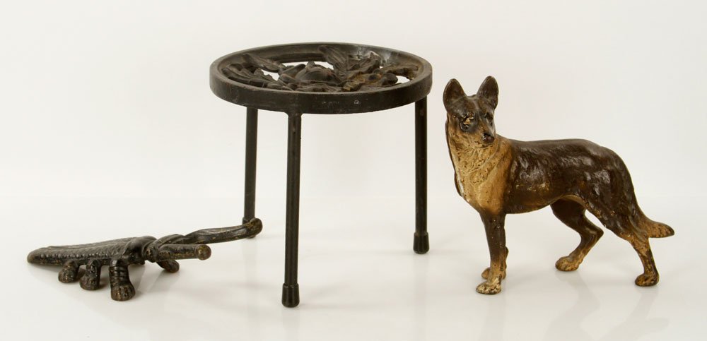 Lot of 3 Cast Iron Items: Lot of three cast iron items, to include: floral trivet, beetle-shaped boot jack and dog-shaped door stop; 8 1/2" h x 8 3/4" dia (trivet). Provenance: From a New Hampshire estate.