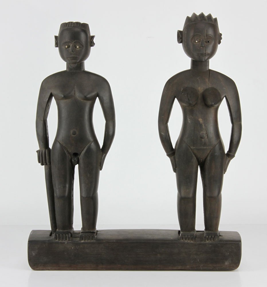 African Carved Wood Figures: Pair of carved wood figures, African, showing a man and woman on a stand, 16" h x 13 1/2" w. Provenance: From the collection of Gilbert Pelham, former Manhattan antiques dealer.