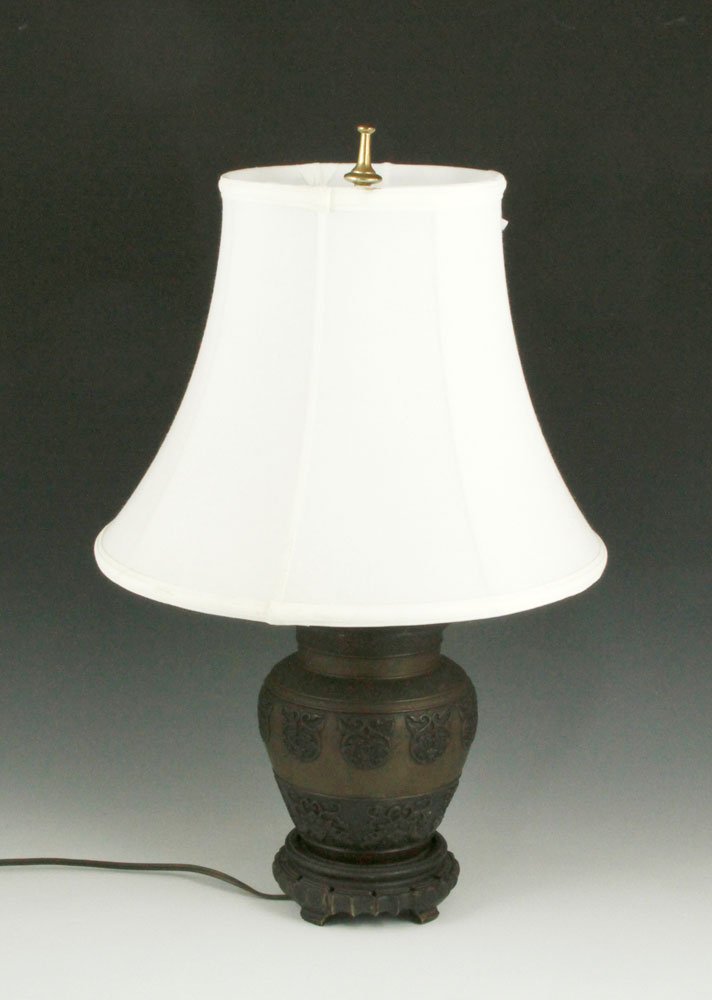 Chinese Bronze Lamp: Chinese lamp, bronze with lotus flower and bat decoration and silk shade, 22 in. (55.88cm) H. Provenance: Dr. Paul and Ann Gardner New of Marblehead, MA were world travelers and big game hunters who l