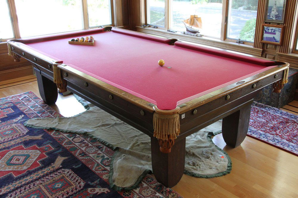 Brunswick Oak Pool Table: Brunswick oak pool table, circa 1910's to 1920's, including balls, cues and marble cue stick rack, 32" h x 109" l x 59" w.