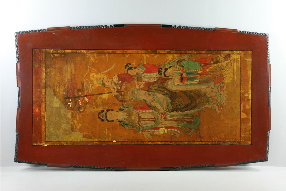 Massive Red and Black Lacquer Coffee Table: Massive red and black lacquer coffee table, laid down with antique Chinese silk scroll of Guanyin figure, scholar and three attendants, sides with ebonized carvings, four scroll legs, 102" w x 50" d.