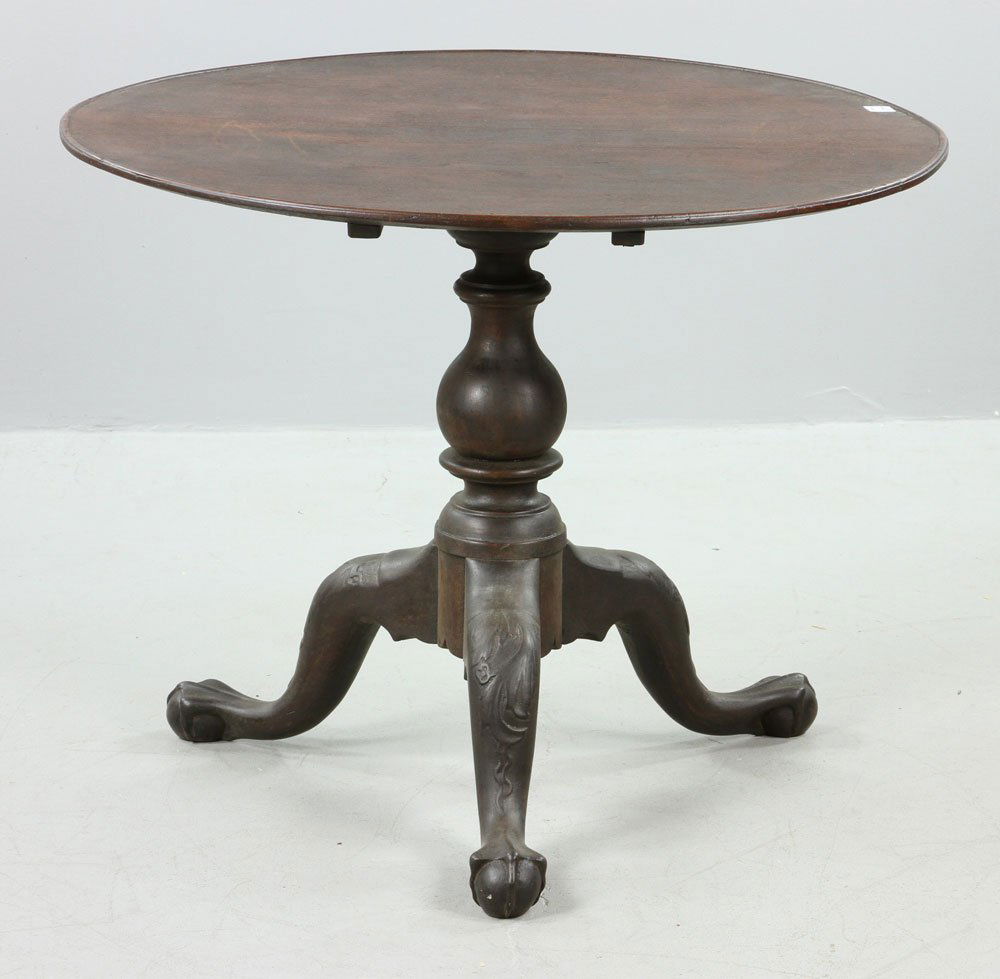18th C. American Tilt Top Champagne Table: American tilt top champagne table, circa 1750, walnut, with round dish top, carved turned shaft topped with cedar block and three legs ending in carved ball-and-claw feet.
