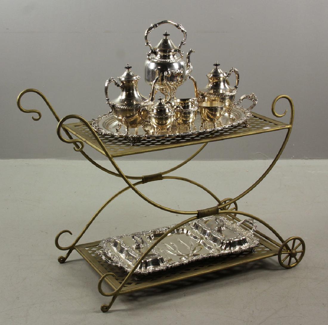 Tea Cart and Service: Wrought Iron tea cart with silver plate tea service and meat tray, 28 1/2" high x 37 1/2" wide x 18 1/2" deep. Provenance: from the estate of a prominent Massachusetts surgeon.