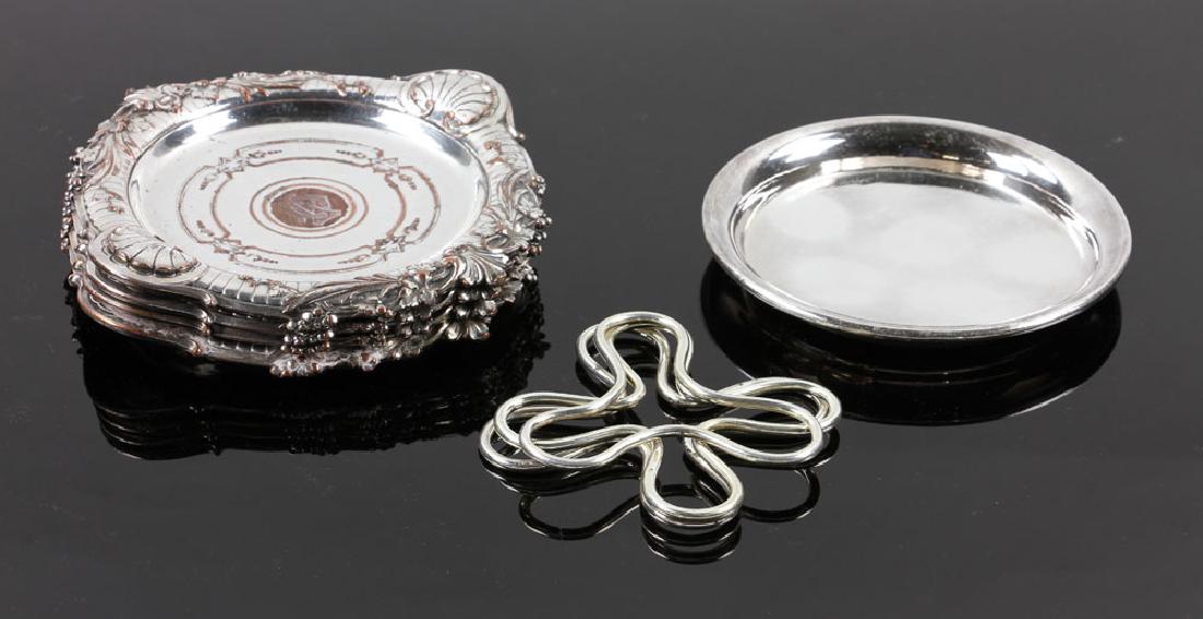 Christofle Silver Wine Coaster Set: Set of four Christofle wine bottle coasters, silver on copper, 6 1/2" dia; with one additional unmatched Christofle silver on copper wine bottle coaster. Provenance: From a Santa Barbara, California e