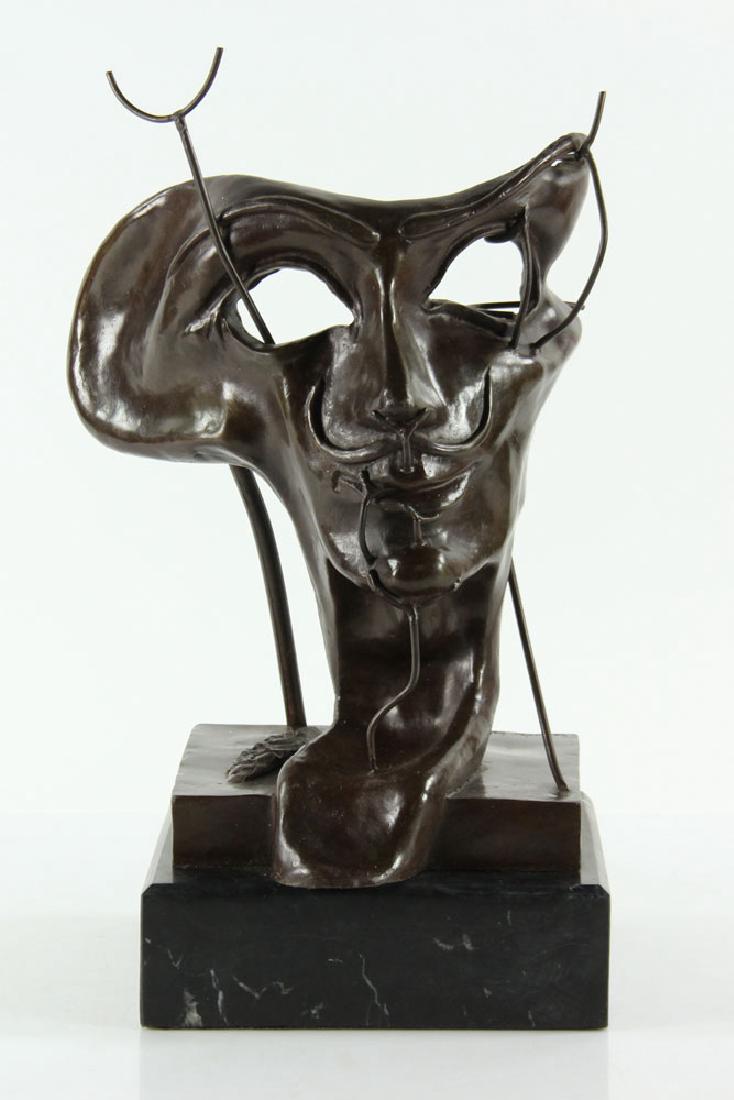 After Dali, Self Portrait Mask, Bronze: After Salvador Dali, self portrait mask sculpture, bronze on marble plinth, signed on base; 15 1/2" h x 9 1/4" w x 7 3/4" d (overall), 2 3/8" h (plinth only). Provenance: From a Hartford, Connecticut 