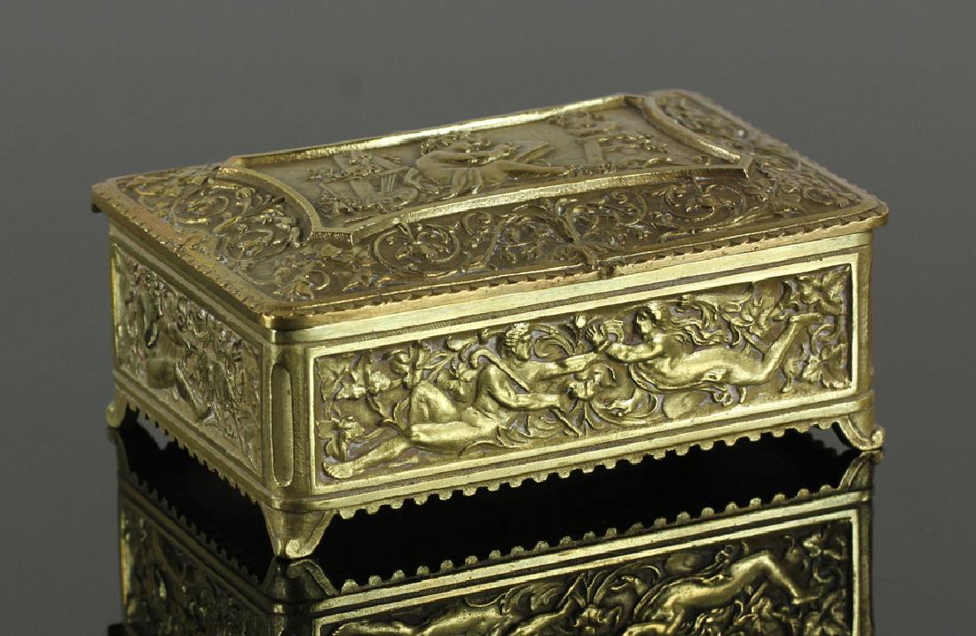 19th C. French Brass Box: French brass box, 19th century, decorated with putti and other classical figures amidst floral scrollwork, 3 1/2" l x 2 1/4" w. Provenance: From a Santa Barbara, California estate.