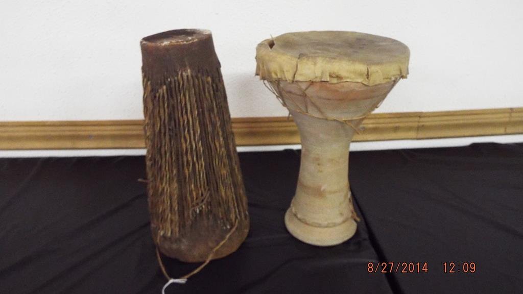 Two drums, one with a ceramic base chipped & leather: Two drums, one with a ceramic base chipped & leather drum top 12"H tear in the leather also an African leather drum 12 1/2"H no ref.#