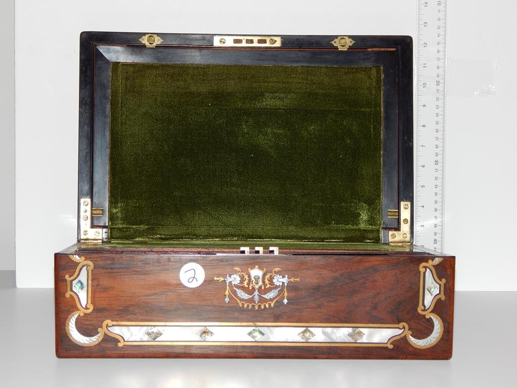 Rosewood lap desk, with beautiful mother of pearl and: Rosewood lap desk, with beautiful mother of pearl and brass inlay, opens to expose felt writing surface with storage below, double glass inkwells, some of the inlay is missing and a piece of corner mo
