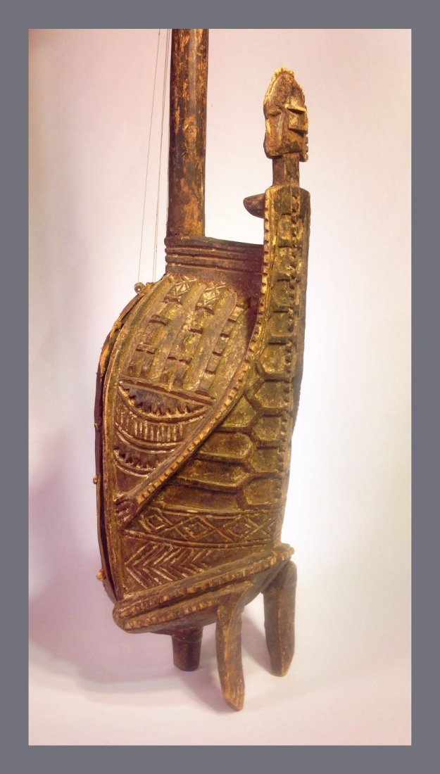 Dogon Ngoni or Bolon Stringed Instrument African Art: This is a fascinating musical instrument from the Dogon culture of Mali, west Africa. carved wood with elaborate Female ancestor on body of instrument, shown kneeling and holding the body with her arm