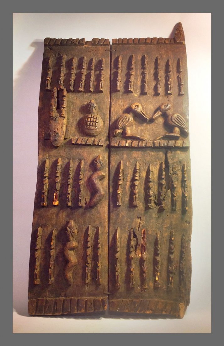 Old Dogon Door with various animal totems, African Art: Old Carved wooden Door from the Dogon culture of Mali, Africa. Featuring two carved panels bound together by hand hammered iron bands , the panels have various motifs carved in relief, including dance