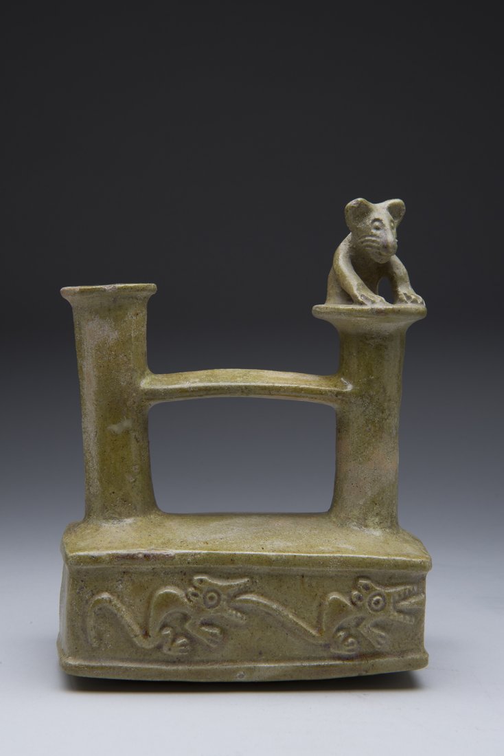 Inca Colonial Stirrup vessel with jaguar motif 1550 AD: Inca Stirrup vessel with Green Majolica glaze which was used during the Spanish colonial era 1550-1600 AD. Featuring a crouching jaguar on spout and running jaguars in relief. Measures 7 x 5 inches.