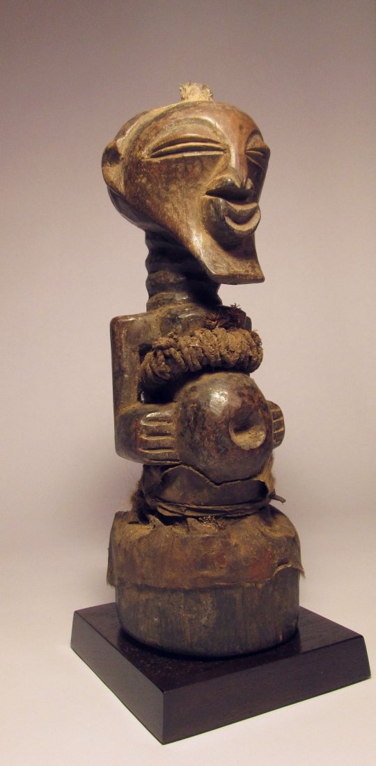 Songye Nkisi magic fetish, African Art: Description: Carved wooden figure with stylized features and adorned with various "magic" regalia, From the Congo, central Africa. A Songye "nganga", or religious specialist, has endowed this carved f