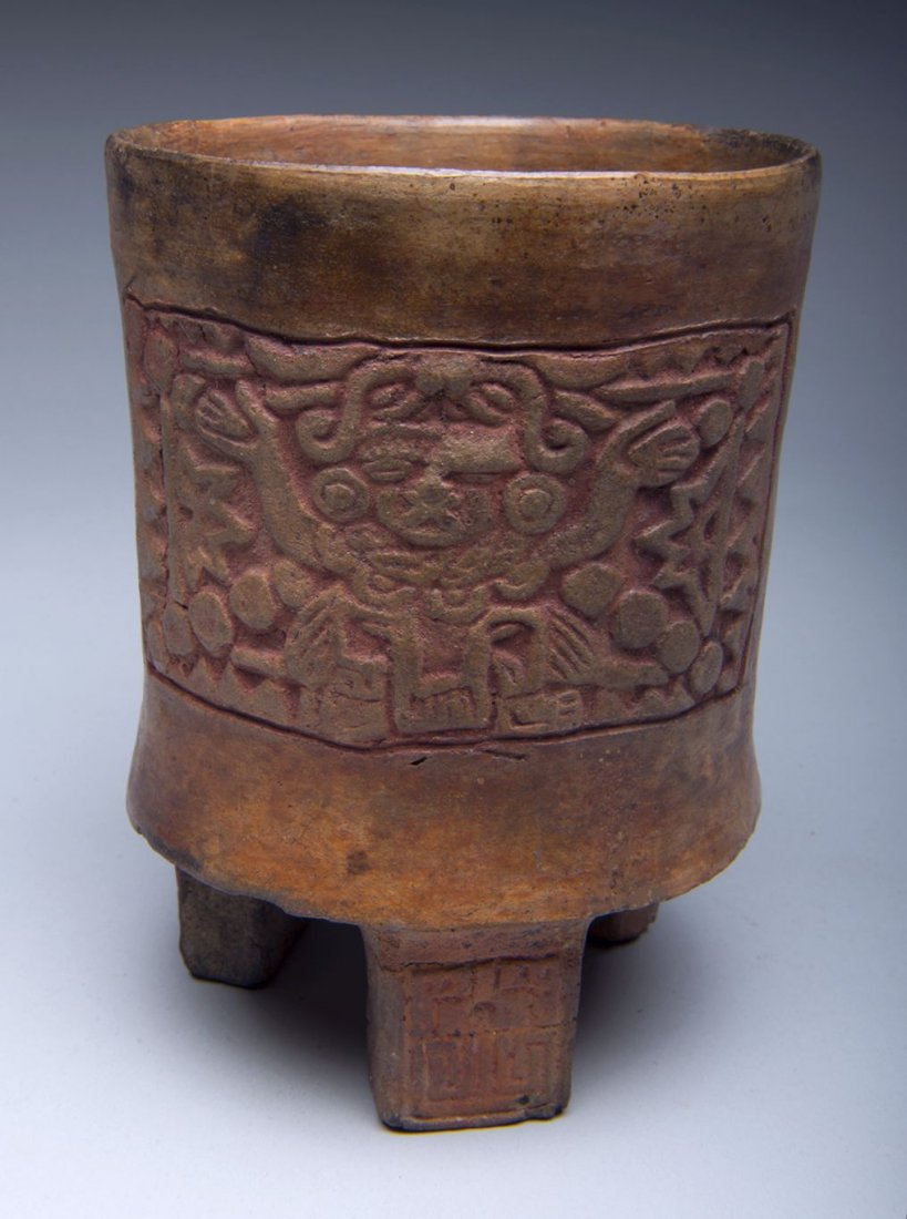 Mayan Tripod vessel with molded deity Pre Columbian: A rare Mayan Tripod vessel with Molded deity glyph, from Guatemala and dating back to approx 550-950 AD. Classic tripod form with fascinating molded deity glyph with hands raised in an intricate desig