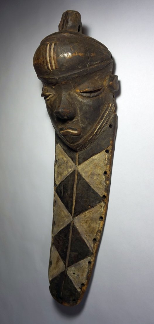Rare Old Pende Muyombo African Mask: This is a rare abstract carved wooden mask from the Pende peoples of the Congo, Africa. The chin extension apparently represents the ancestral beard. It is called "mwevu" and it is meant as a symbol f