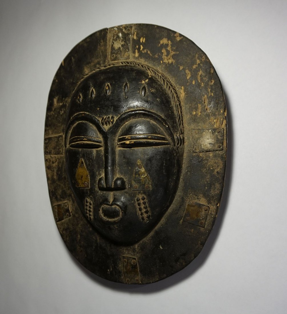 Lovely Old Baule Moon Mask, African Tribal Art: This is a fascinating old wooden mask from the Baule Peoples of West Africa. Carved wood with large traditional face surrounded by wide border, accented with metal strips. Reportedly represents the Mo