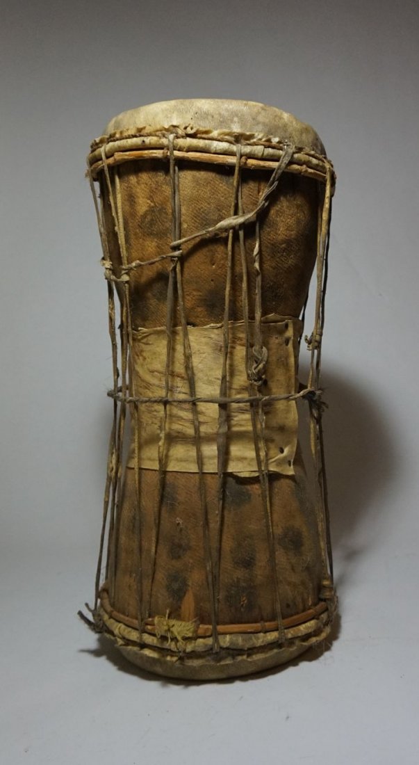 Old West African Dun Dun Talking Drum from Nigeria: Old and well used Dun Dun or Talking Drum from Nigeria, West Africa. Carved wood with animal hide skins attached with long thick strands of sinew, used to squeeze and change the pitch of the drum, a c