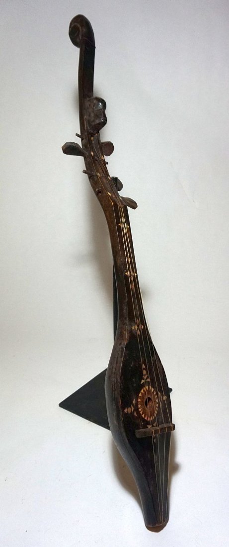 Tribal Style Lute from Sumatra , Indonesian Musical: Carved wooden lute in a wonderful tribal style, likely from the Batak peoples of Sumatra, Indonesia.With inlaid designs and a carved ancestor head on the finial. Measures 31 x 4 inches.