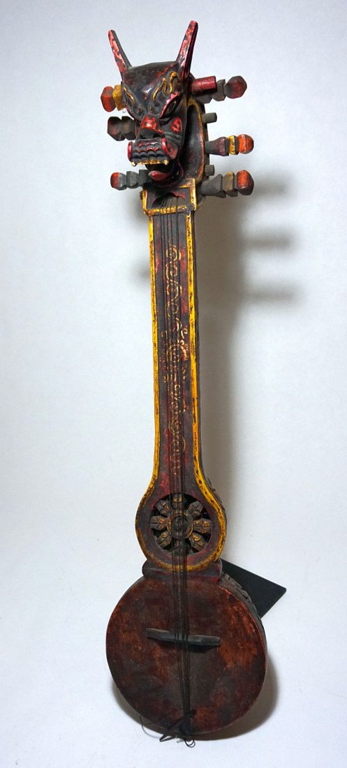 Dragon head lute from Nepal, Buddhist Inscribed design: The Tuguna is a wooden,long-necked lute often found with a horse or dragon head terminal. It is unfretted and usually has six strings tuned in double courses, and is a traditional style for Bhutan and