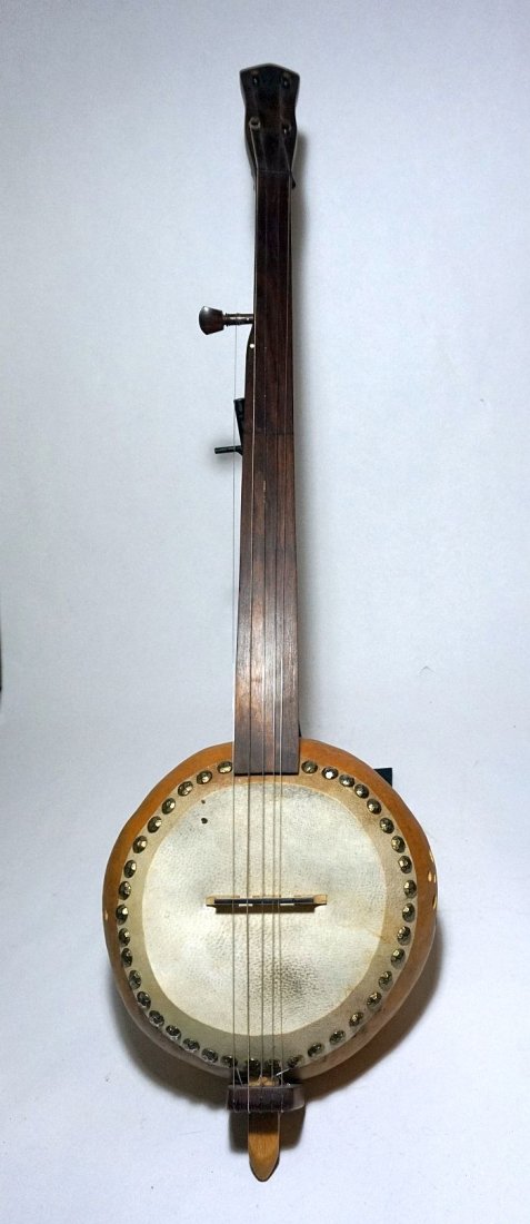A Fine Gourd Banjo, Musical Instrument: A very fine Gourd banjo, with a carved wooden neck and an actual hollowed out Gourd as the body and resonating chamber. Measures 36 inches long and 9 inches wide.