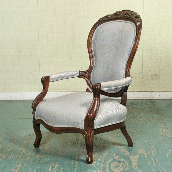 Late 1800's Rococo Victorian open arm chair, solid: Late 1800's Rococo Victorian open arm chair, solid walnut, fruit carved crest, molded back, cabriole legs, 42" tall, 26" wide, 33" deep. Later finish.