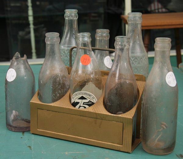 Lot of eight old soda bottles, includes old tin C: Lot of eight old soda bottles, includes old tin Coca-Cola Bottling Co. carrier with extending handle, included are bottles from Camden, Greenville, Enterprise (broken), Evergreen, Selma (75th Annivers